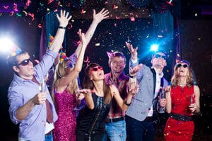Cheerful young people showered with confetti on a club party.